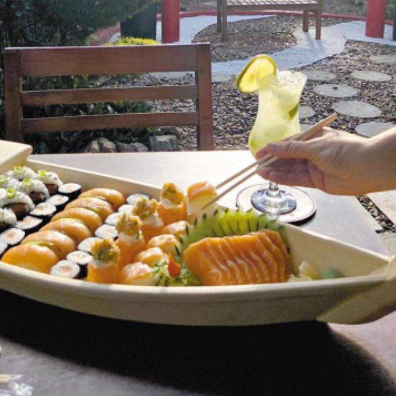 No jardim externo, um pórtico com banco dá o clima da temakeria, que antes era somente delivery